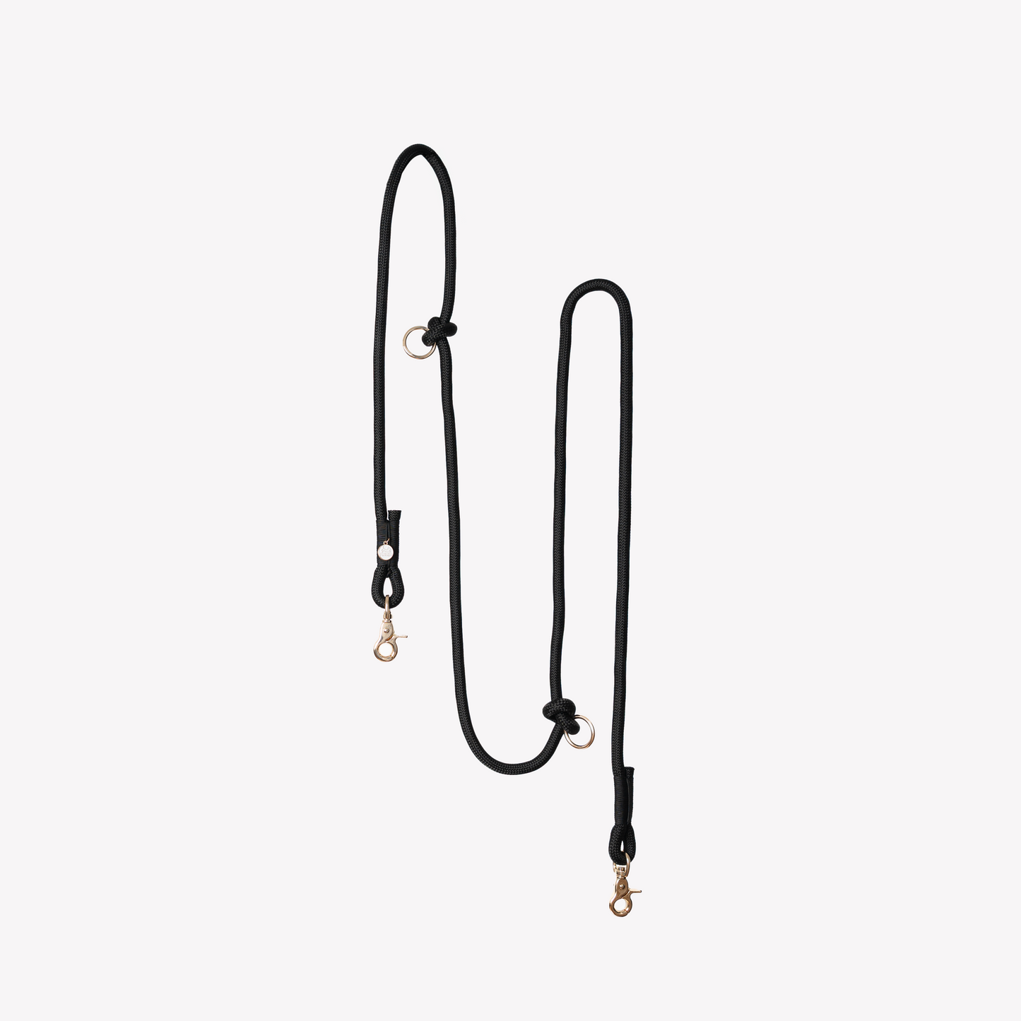 Black hands-free dog leash with gold hooks on a white background