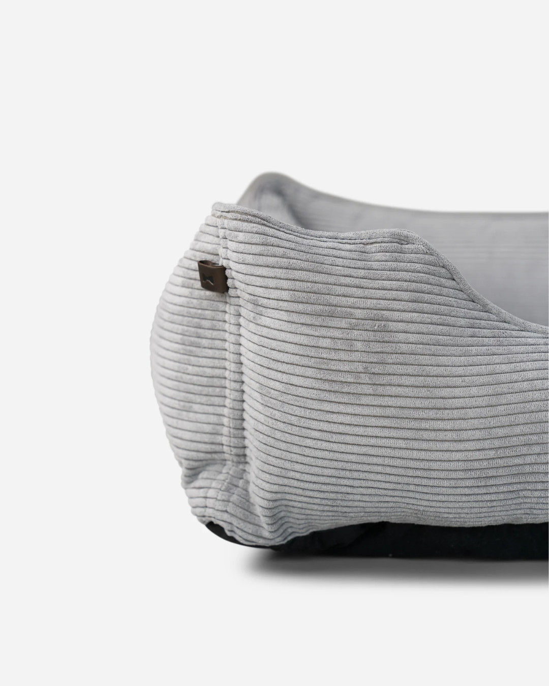 Close-up of a gray corduroy bag with a brown button on a white background