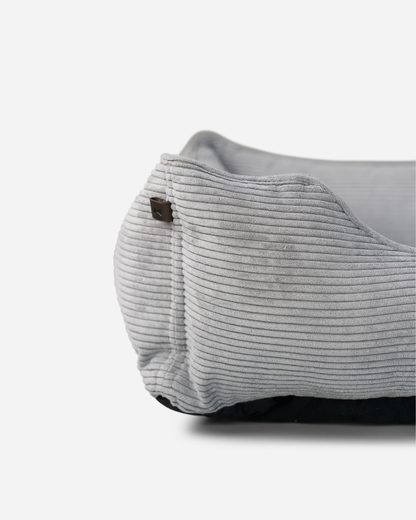 Close-up of a gray corduroy bag with a brown button on a white background