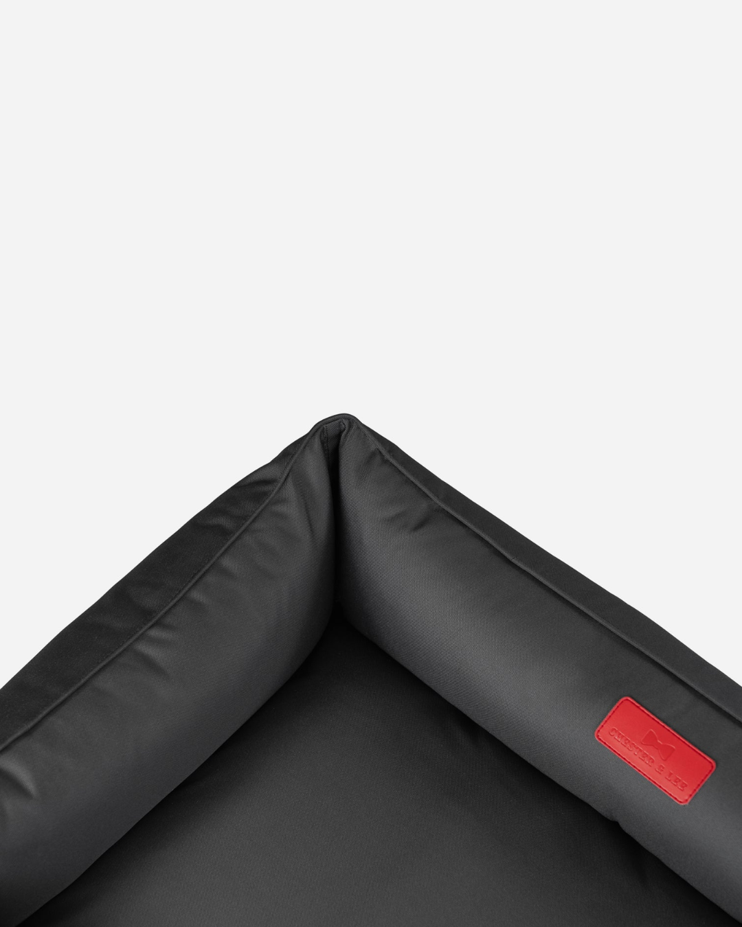 Close-up of the bed's raised side and red brand patch