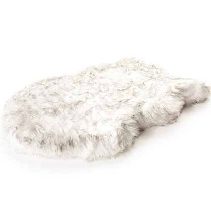 Empty curved white PupRug faux fur orthopedic dog bed against a white background.