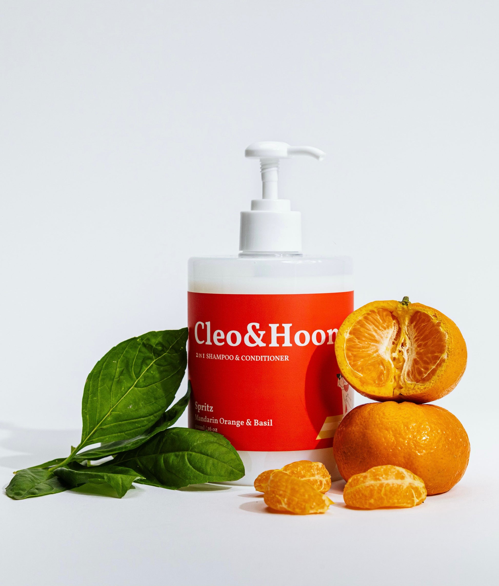 Cleo & Hoon shampoo bottle with oranges and basil leaves on a light background