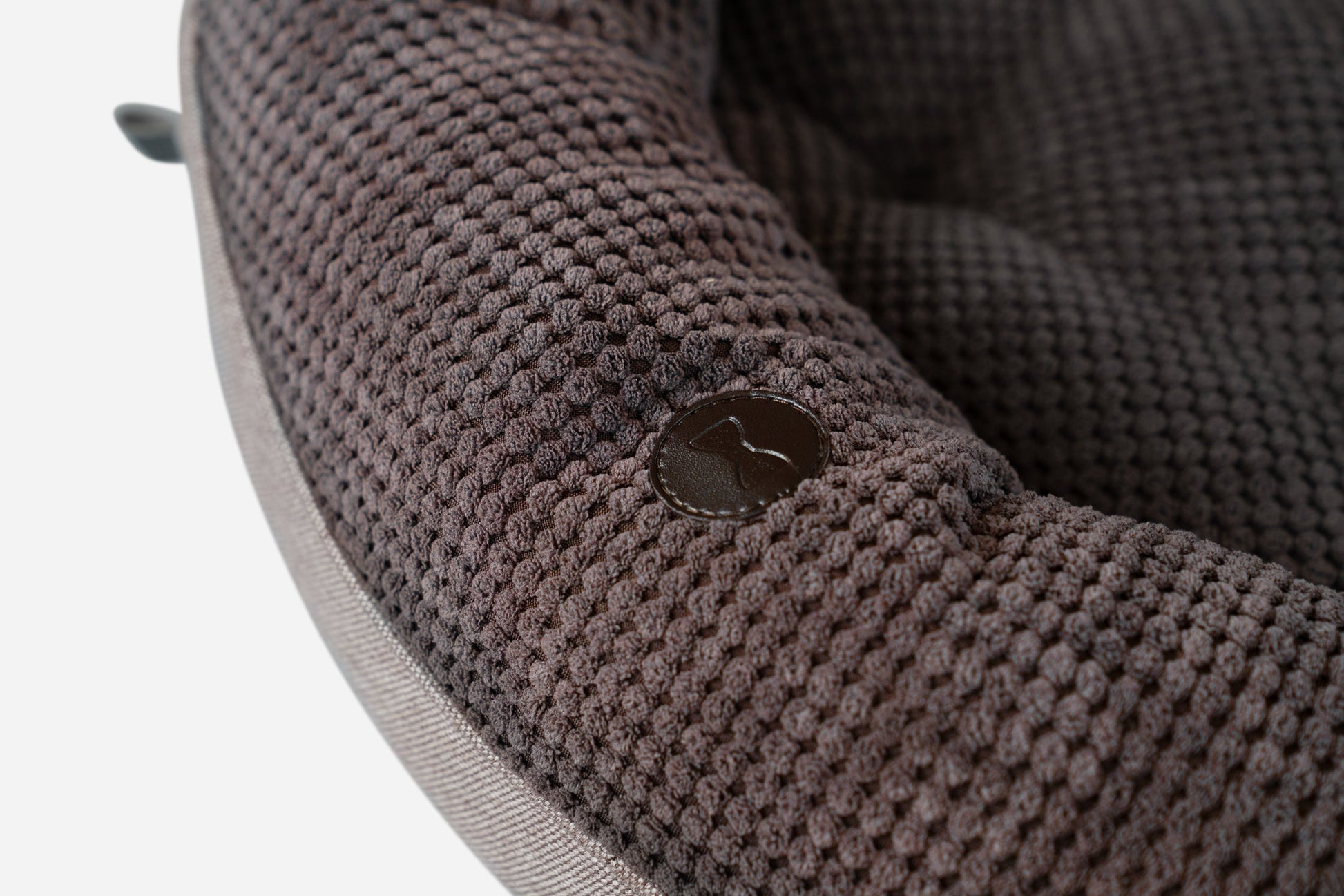 Close-up of a textured brown fabric surface with a button.