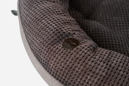 Close-up of a textured brown fabric surface with a button.