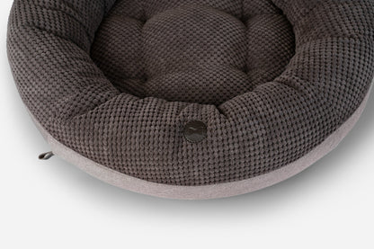 Round knitted pet bed on a white background