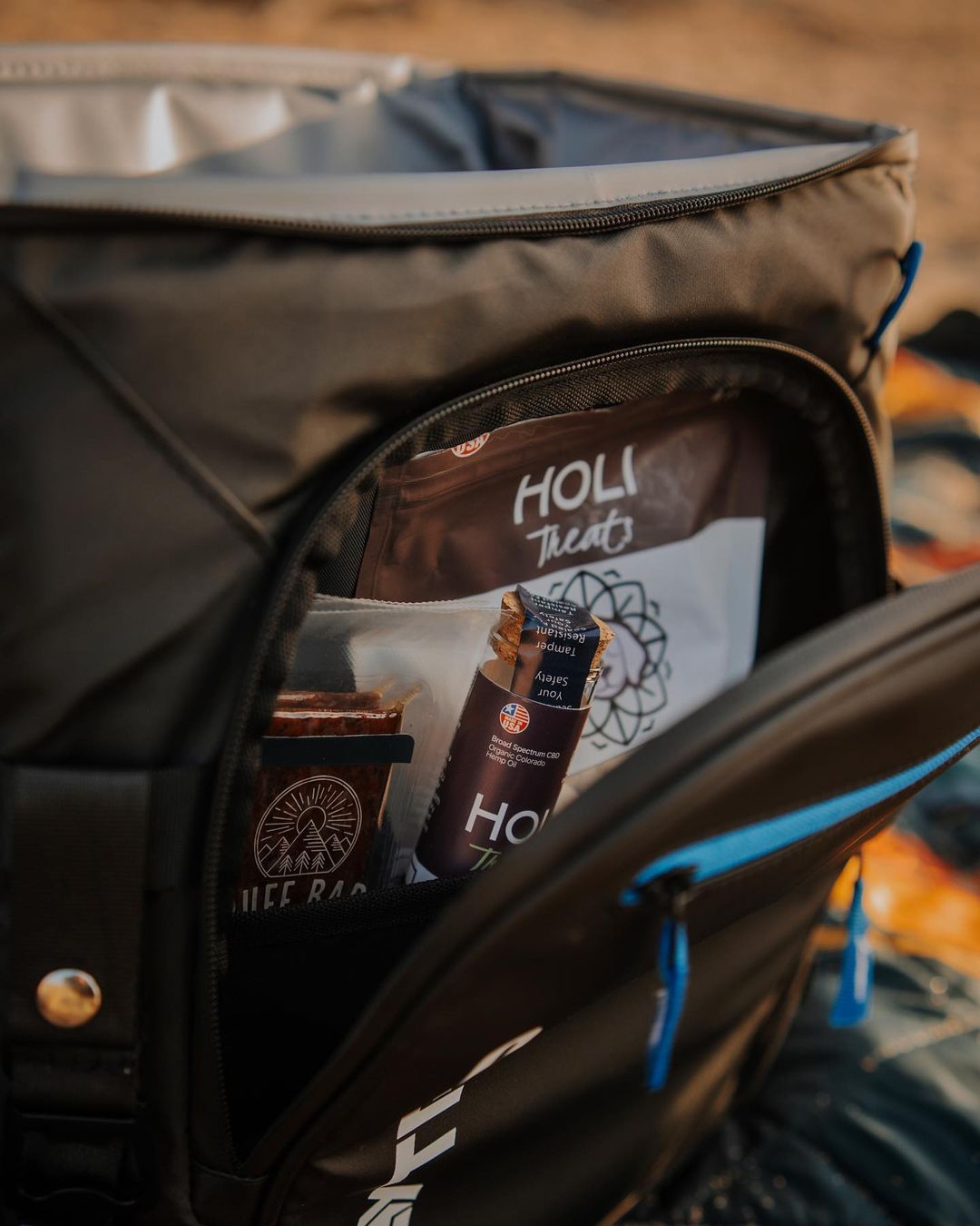 HOLI Elk & Venison Dog Treats shown with outdoor pet gear