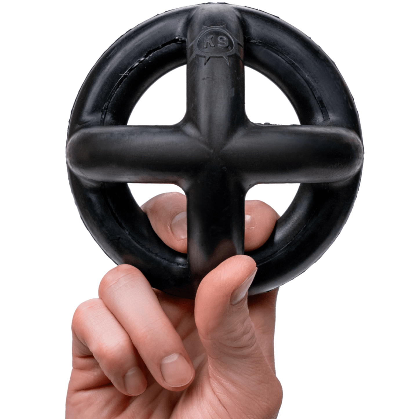 Black rubber dog toy held in a hand against a white background