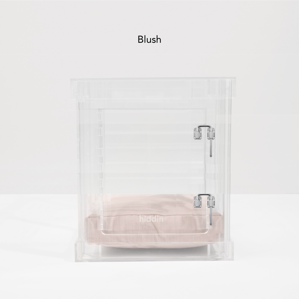Small clear pet crate with blush cushion and silver latch